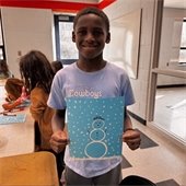 student holding a painting of a snowman 