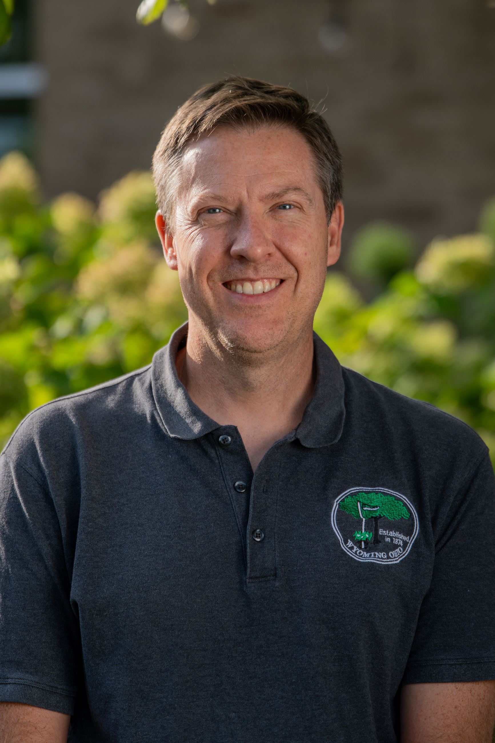 man with gray polo smiling at camera